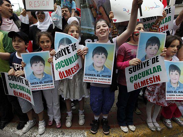 Pred sirskim veleposlaništvom v Carigradu so se zbrali v Turčiji živeči sirski otroci, ki so v rokah držali fotografijo enega izmed ubitih sirskih otrok. Na plakatih piše: 'Ne pustite, da otroci v Siriji umirajo.' Foto: Reuters
