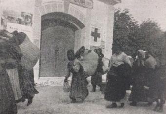 Gališki begunci na poti mimo kamniškega gasilnega doma.