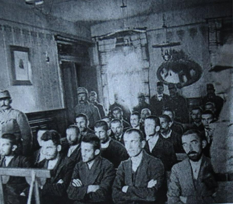 Atentatorji v sodni dvorani. Fotografirano z druge strani dvorane. Nedeljko Čabrinović  je drugi z leve, tretji pa Gavrilo Princip.