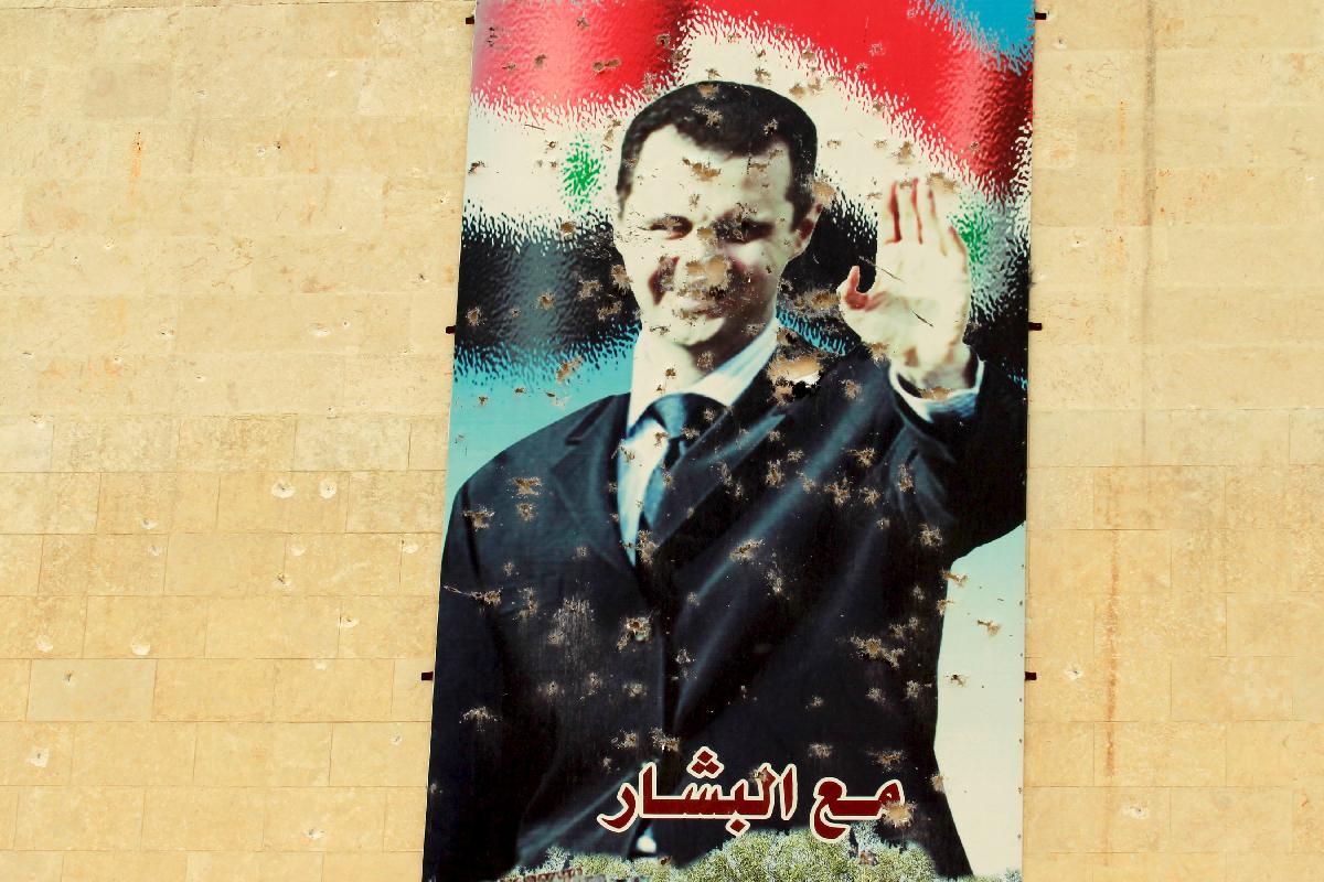 Ustreljeni plakat Bašarja al Asada v Idlibu