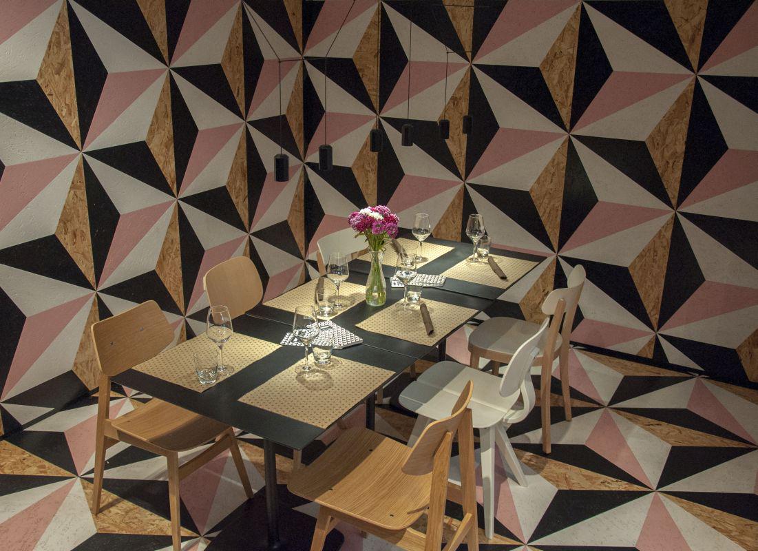'Zasankano podlogo' tvorijo geometrijski vzorci velikih trikotnikov v pastelno roza barvi, črno-beli kombinaciji in naravni barvi OSB-plošč. Foto: MMC RTV SLO/Katja Štok