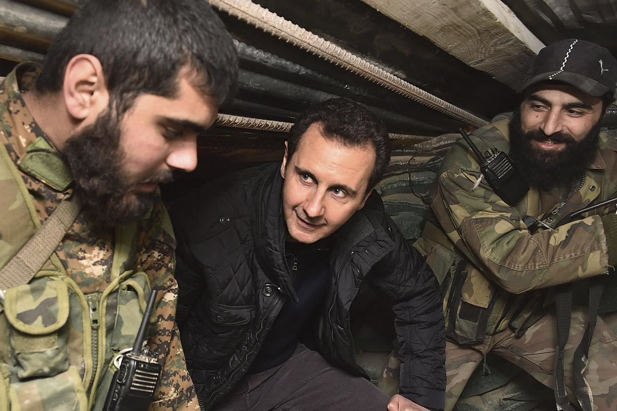 Bašar Al Asad je trdoživ, po 4 letih državljanske vojne mu je zdaj na pomoč uspelo priklicati še velesilo Rusijo, kar mu zagotavlja preživetje. A vprašanje ostaja, ali je mir mogoč, če bo on še naprej predsednik Sirije. Slika z novoletnega obiska fronte v Džobarju, predmestju Damaska, je pomenljiva za Asada: levi vojak je padel aprila, desni pa se je kot begunec zatekel v Evropo. Foto: Reuters