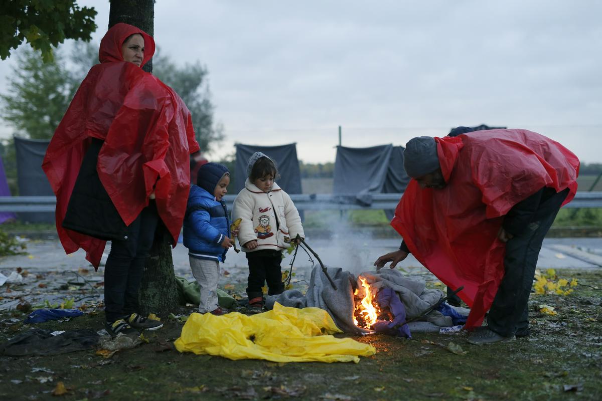 Del čakajočih prebežnikov se na hrvaški strani meje greje tako, da kuri ogenj. Foto: Reuters