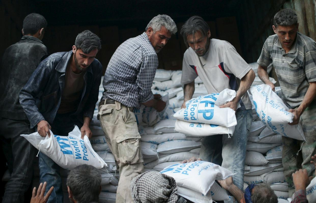 Tovornjaki so v Rastan pripeljali najnujnejša živila in zdravila. Na sliki raztovarjanje vreč z moko. Foto: Reuters