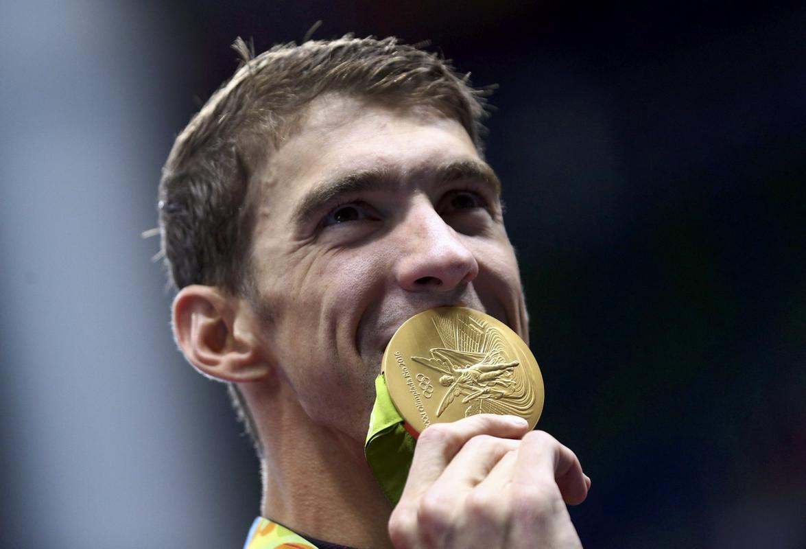 Michael Phelps s svojo zadnjo olimpijsko medaljo. Američan je še enkrat potrdil, da se s tem poslavlja od aktivnega plavanja. Nekateri novinarji v Riu so prepričani, da se bo vrnil pred igrami v Tokiu. Foto: Reuters