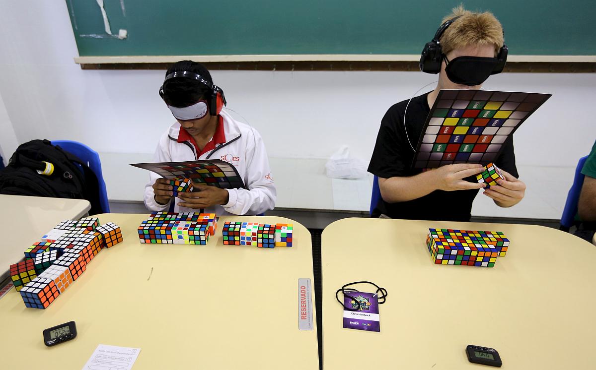 Tekmovalci se na srečanjih pomerijo tudi v reševanju kocke z zavezanimi očmi. Foto: Reuters