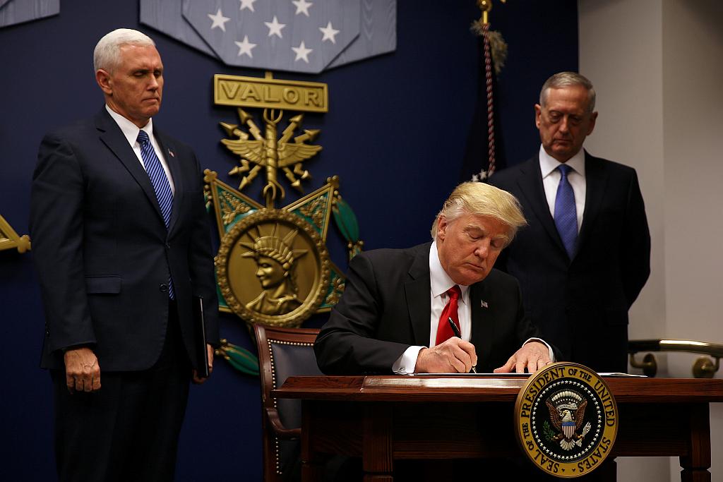 Donald Trump med podpisom spornega odloka, ki ga je obljubljal že v času volilne kampanje. Foto: Reuters