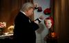 Nova figura Donalda Trumpa, ki se znaša nad fotografijo Angele Merkel