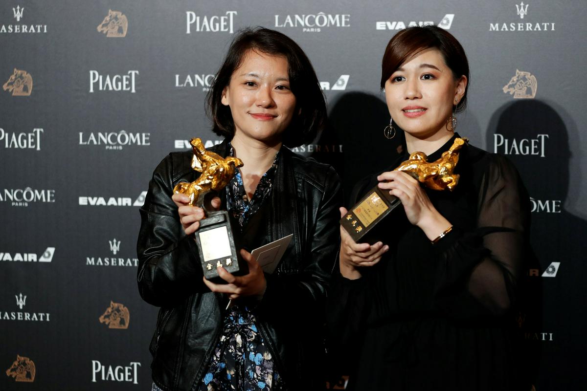 Tajvanska režiserka Yue Fu (na desni) z nagrado zlati konj, ki jo je v kategoriji najboljšega dokumentarca osvojila za film Naša mladost v Tajvanu. Foto: Reuters