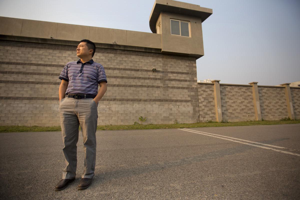 Liu Hu pred centrom za pridržanje na obrobju Pekinga, kjer je bil po lastnih besedah zaprt leto dni in mučen. Foto: AP Photo/Mark Schiefelbein, File