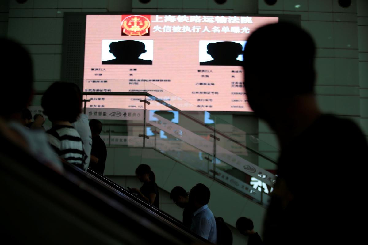 Javni zaslon v Šanghaju s podatki para Kitajcev, ki nista plačala dolgov. Končala sta na enem izmed črnih seznamov, ki so integralen element Sistema javnega slovesa. Foto: Reuters/Aly Song