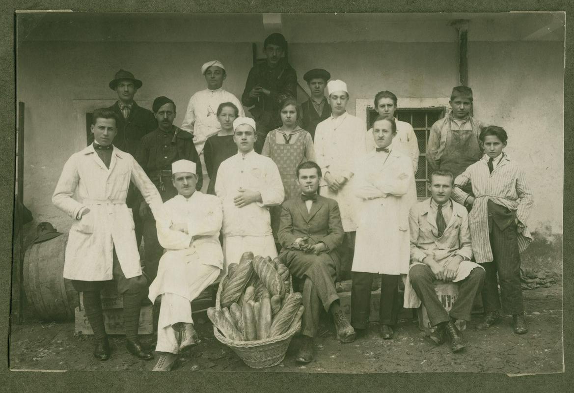 Postojnski obrtniki, ok. 1924. Med njimi brivci Viktor Ozbič (skrajno levo), njegov brat Adolf Ozbič (skrajno desno) in Rafael Milavec (spredaj, tretji z desne). Fotografirano za Ditrichovo hišo v Postojni. Foto: Janko Ozbič