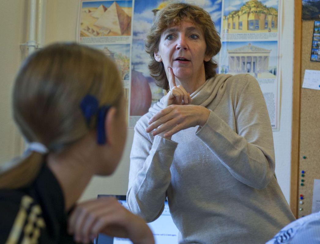 Na fotografiji je tolmačka v znakovni jezik, ki tolmači gluhi deklici. Foto: EPA Foto: dostopno