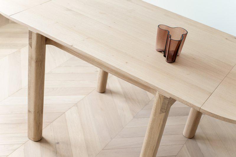 ... lahko pa je tudi velika miza za šest gostov. Na mizi vaza finskega oblikovalca Alvarja Aalta. Ime njegove žene, prav tako oblikovalke Aino Aalto, pa se skriva tudi v imenu arhitekturnega biroja AINO, ki sicer pomeni arhitektura in oblikovanje. Foto: Studio Aino