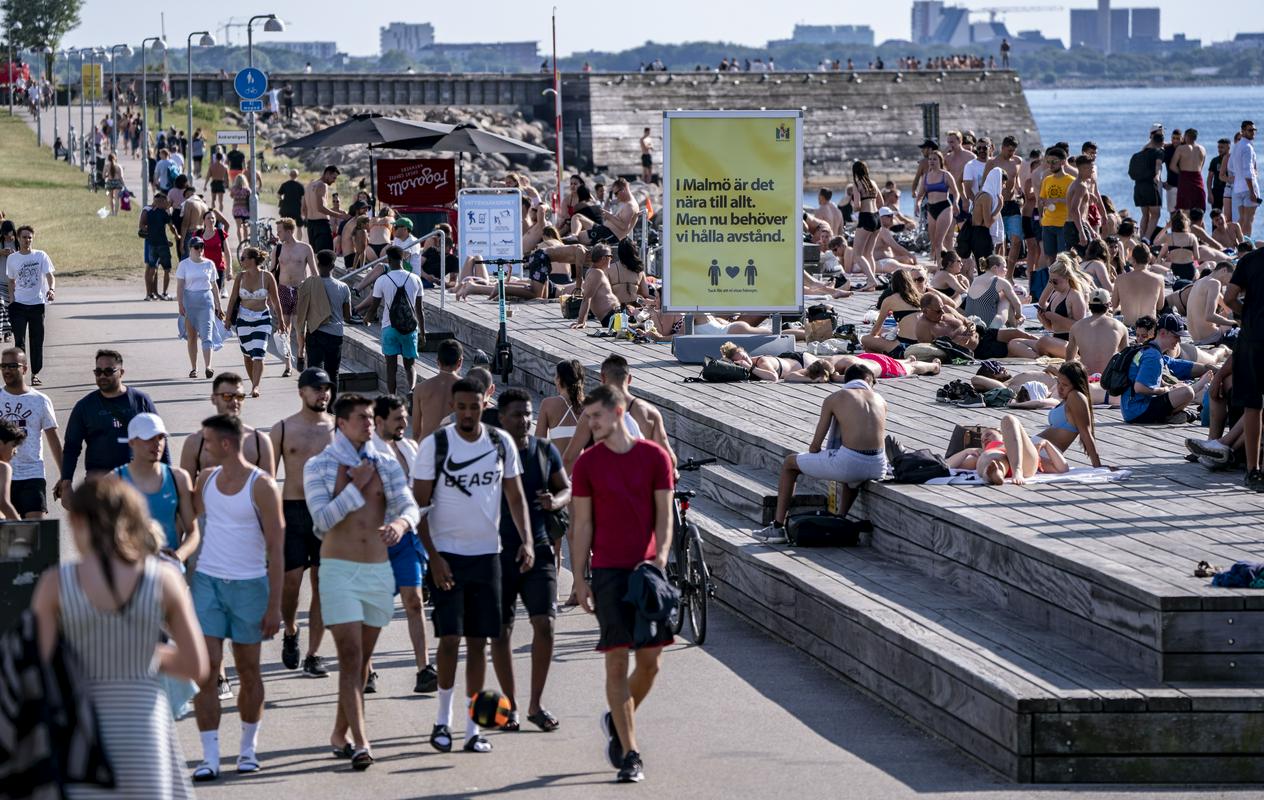 Prebivalci Malmöja uživajo v poletnem vremenu. Švedsko je v tem tednu zajel pravi vročinski val, saj so se temperature na jugu države povzpele nad 30 stopinj Celzija. Na plaži je tudi opozorilo (v rumenem), naj ljudje upoštevajo pravilo družbenega oddaljevanja. EPA