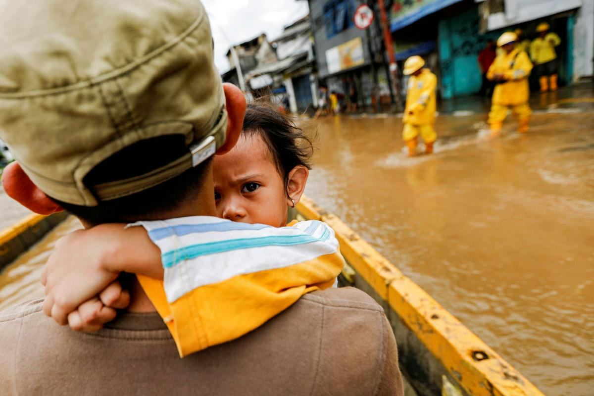Oče rešuje deklico, potem ko so indonezijsko prestolnico Džakarto januarja zajele poplave. Foto: Reuters