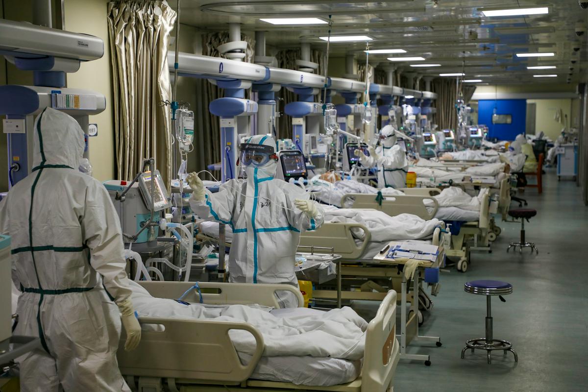 Januarske prizore iz Kitajske, ko so zdravstveni delavci v skafandrih oskrbovali bolnike s covidom-19, je preostali svet opazoval z zanimanjem, misleč, da njih to gotovo ne čaka. Zdaj je to že mesece realnost za domala ves svet. Foto: Reuters