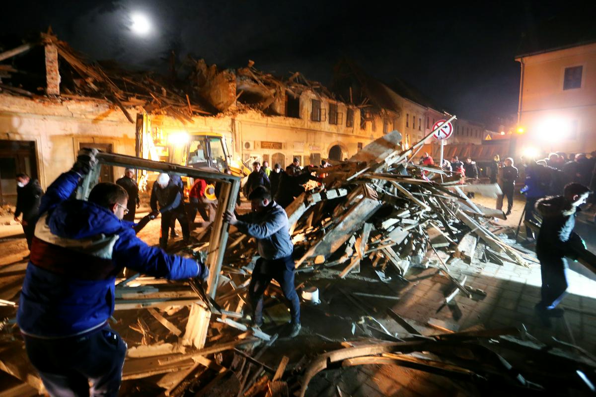 Prostovoljci in reševalne službe v Petrinji odstranjujejo ruševine. Foto: Reuters