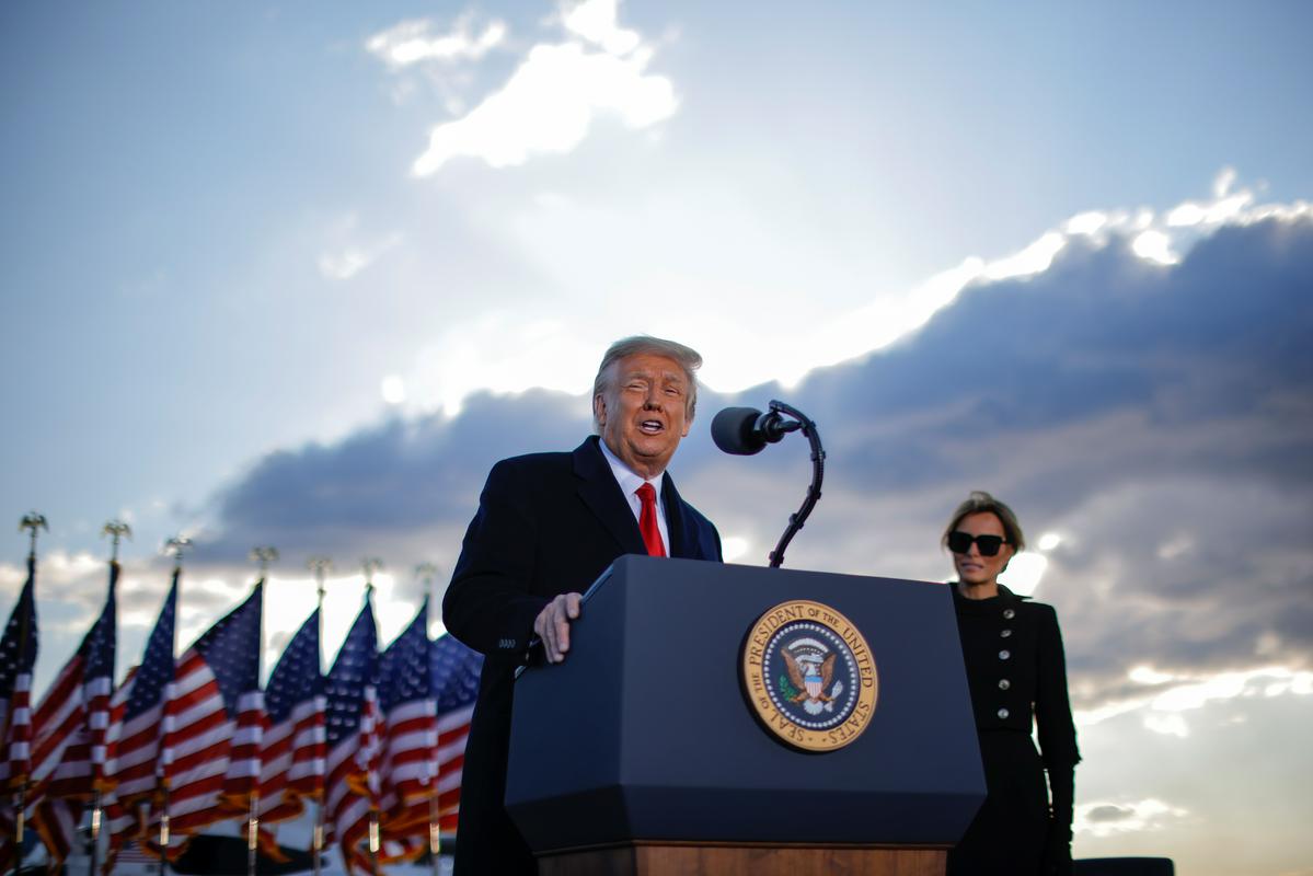 Trump med zadnjim govorom v vlogi predsednika v letalskem oporišču Andrews v Marylandu. Desno Trumpova žena Melania. Foto: Reuters