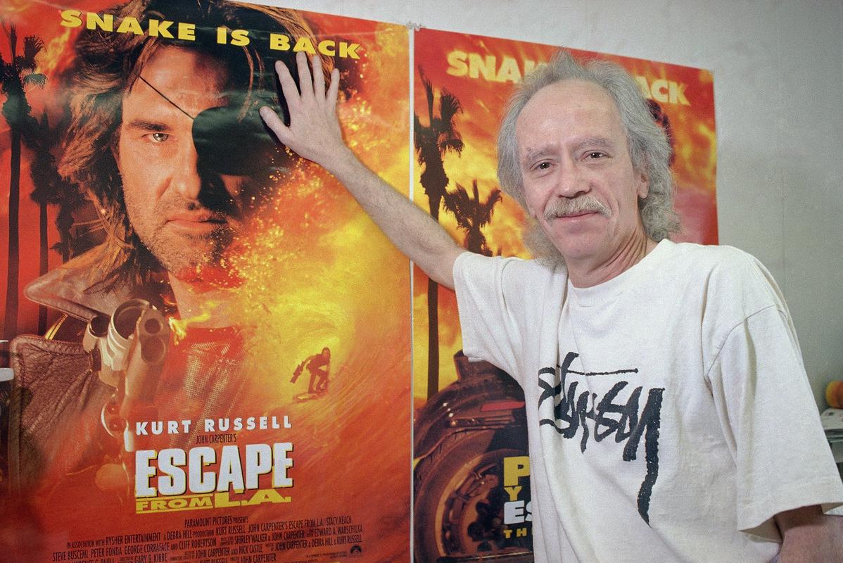 John Carpenter leta 1996 ob plakatu za svoj film Escape from L. A., nadaljevanje filma Escape from New York. Foto: AP