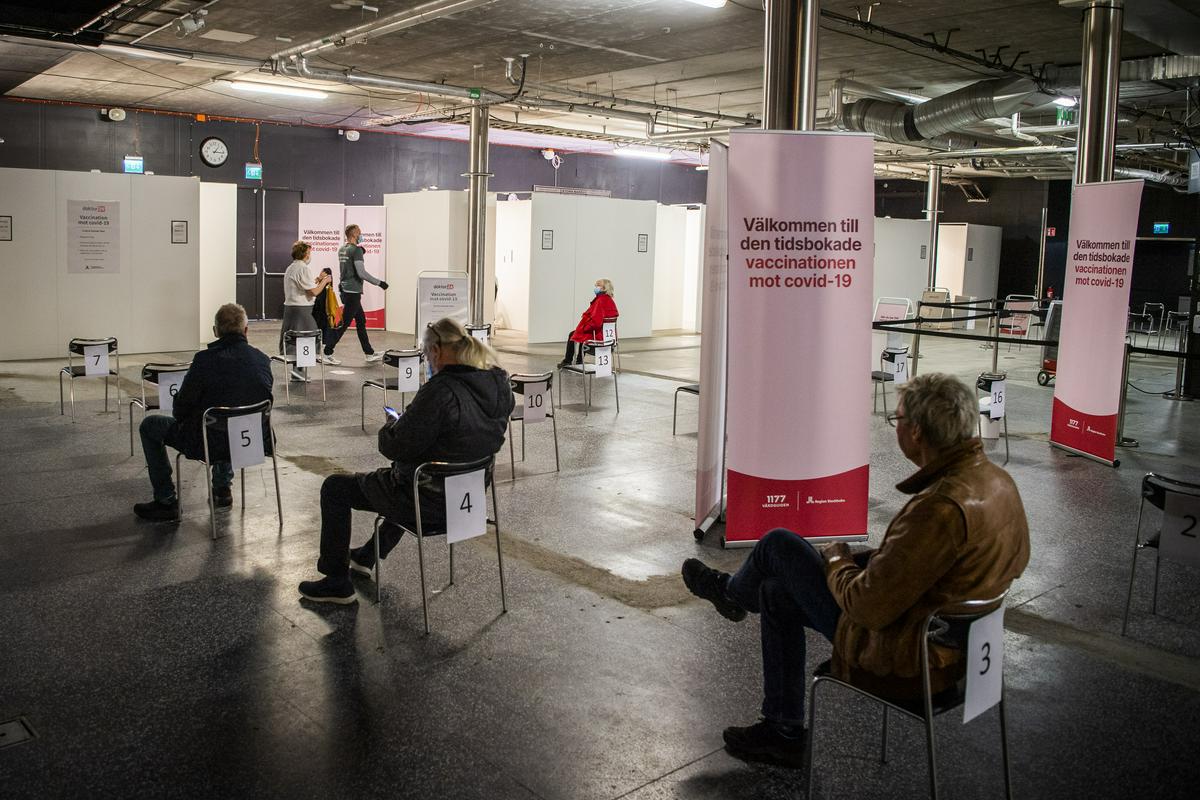Ljudje čakajo na cepljenje v cepilnem centru v Stockholmu. Foto: EPA