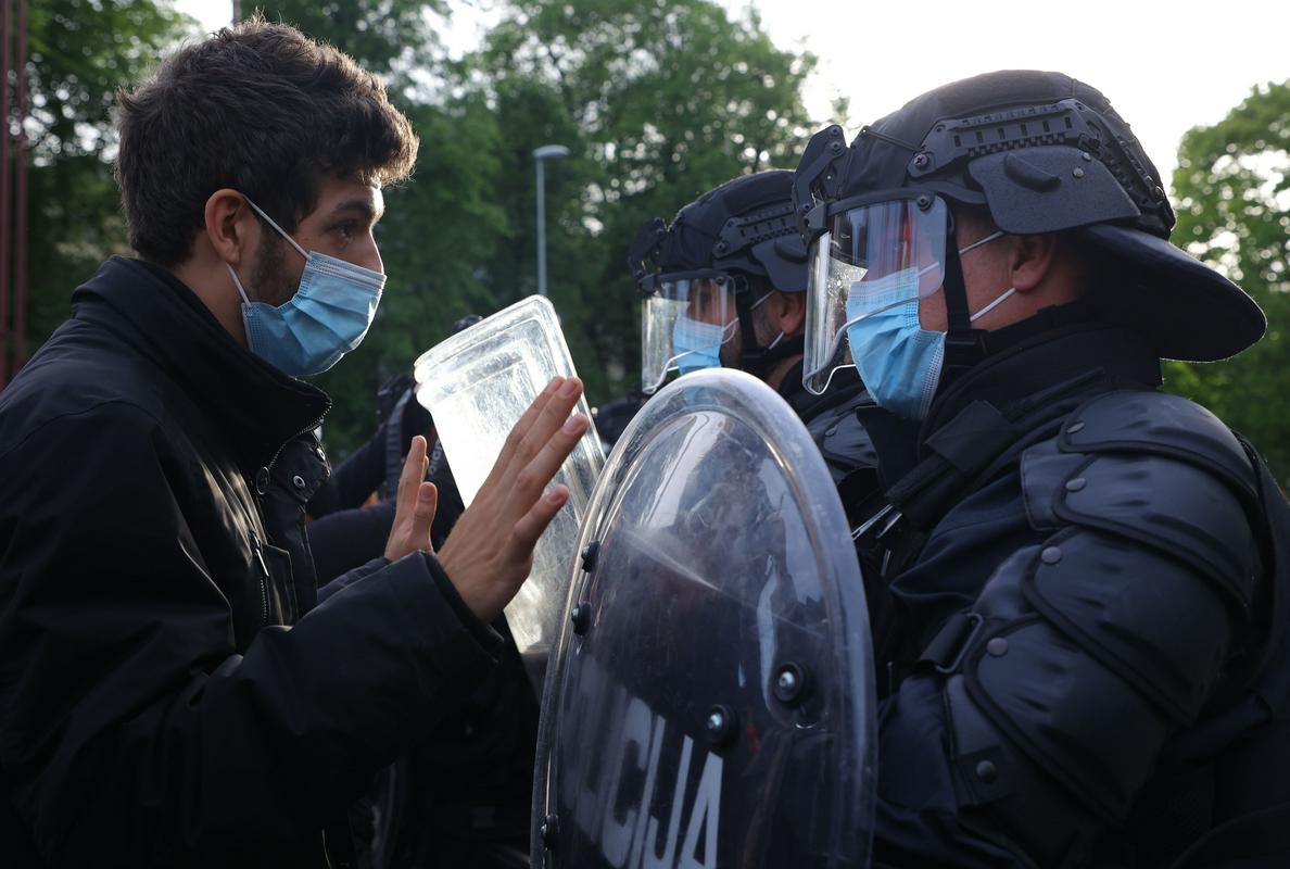 Policija in eden izmed udeležencev petkovega protesta. Foto: BoBo