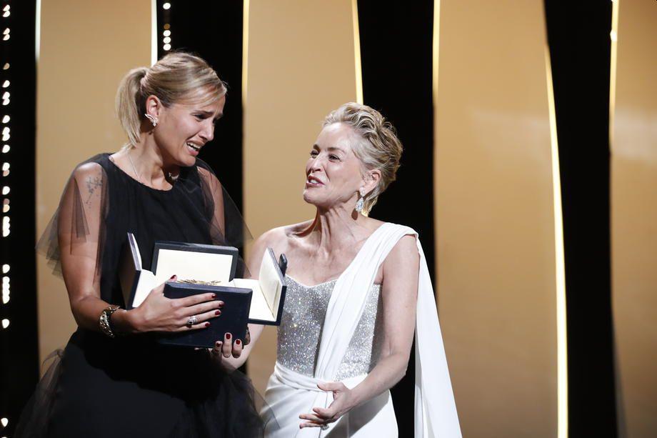 Zlato palmo je francoska režiserka Julia Ducournau prejela iz rok ameriške igralke Sharon Stone (desno). Foto: EPA