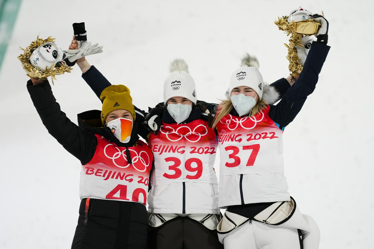 Nepozabna fotografija z dvema Slovenkama na olimpijskih stopničkah. Družbo je Urši Bogataj in Niki Križnar delala Nemka Katharina Althaus. Foto: AP