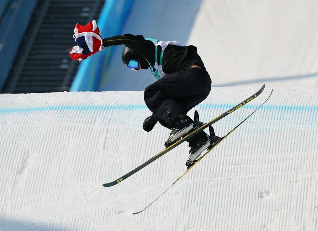 Norvežan Birk Ruud je že pred zadnjim skokom vedel, da je novi olimpijski prvak, zato je lahko nastopil kar z norveško zastavo. Foto: Reuters