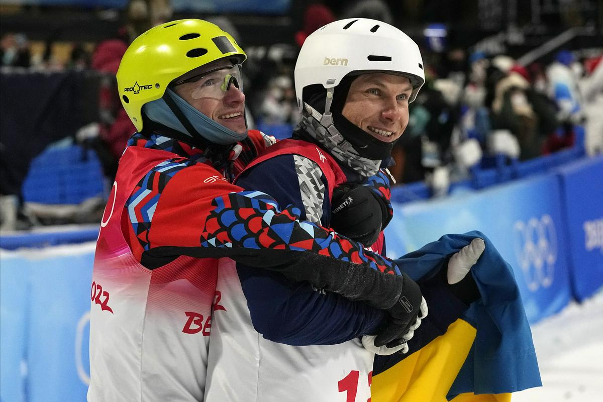 Na preteklih zimskih igrah je Ukrajina osvojila le eno medaljo – srebrno odličje v skokih smučanja prostega sloga. Na sliki trenutek, ko je bronasti Rus Ilja Burov objel srebrnega Oleksandra Abramenka, odetega v ukrajinsko zastavo. Foto: EPA