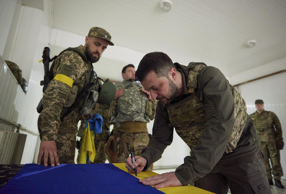 Zelenski se v Harkovu podpisuje na ukrajinsko zastavo. Foto: EPA