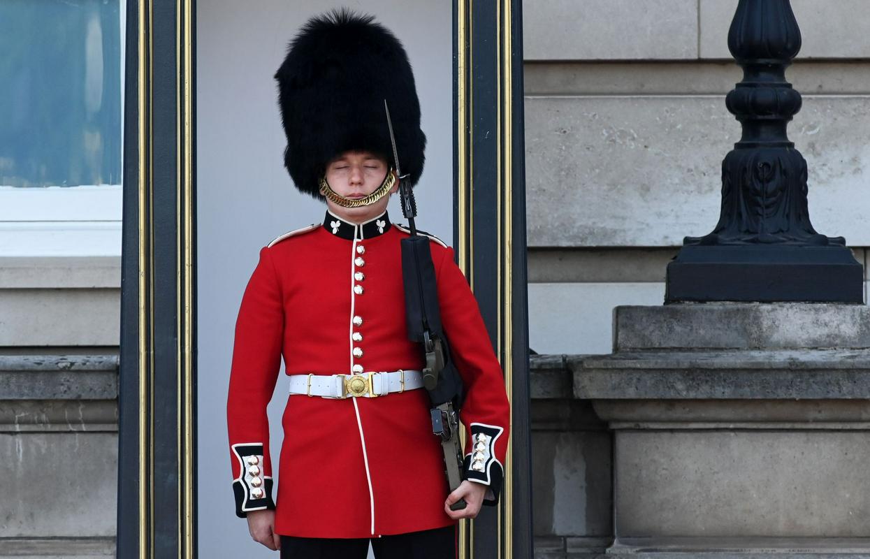 Um membro da guarda de honra britânica do lado de fora do Palácio de Buschingham luta contra o calor usando um chapéu de pele de urso.  Foto: EPA