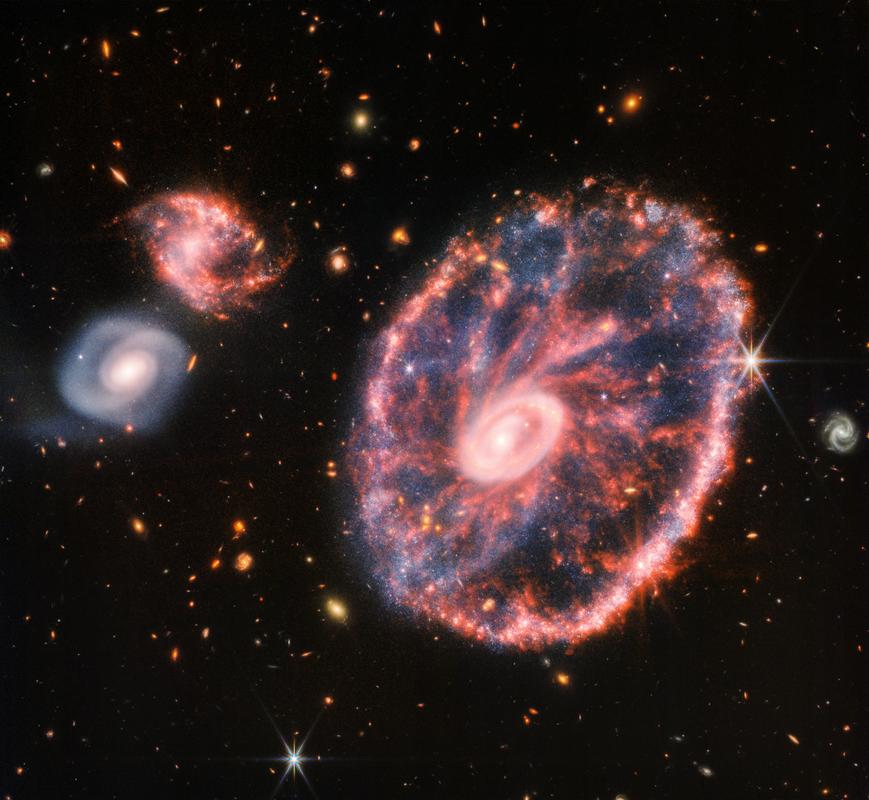 Vozno kolo je največja galaksija na fotografiji. Široka je okoli 150.000 svetlobnih let in je torej večja od domače Galaksije. Foto: NASA, ESA, CSA, STScI, Webb ERO Production Team