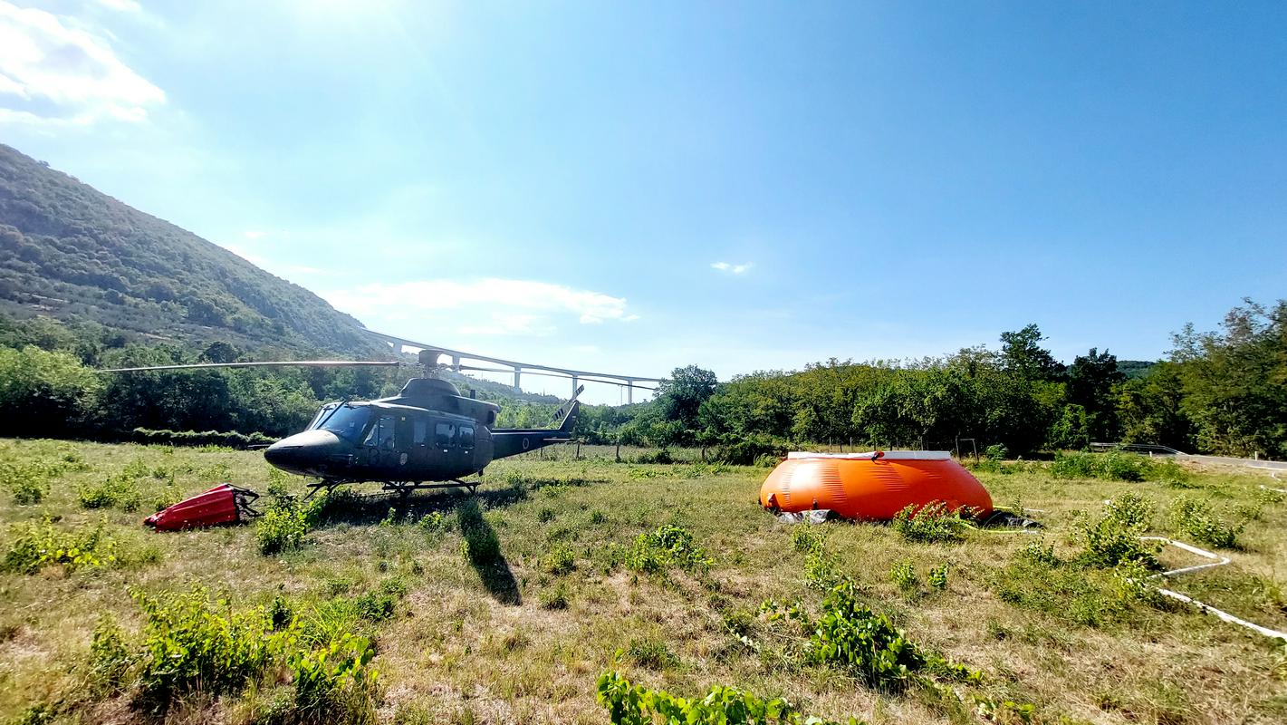 Tako kot na intervencijah na goriškem Krasu gasilcem tudi tokrat pri gašenju pomaga vojaški helikopter. Foto: Televizija Slovenija/Edi Mavsar