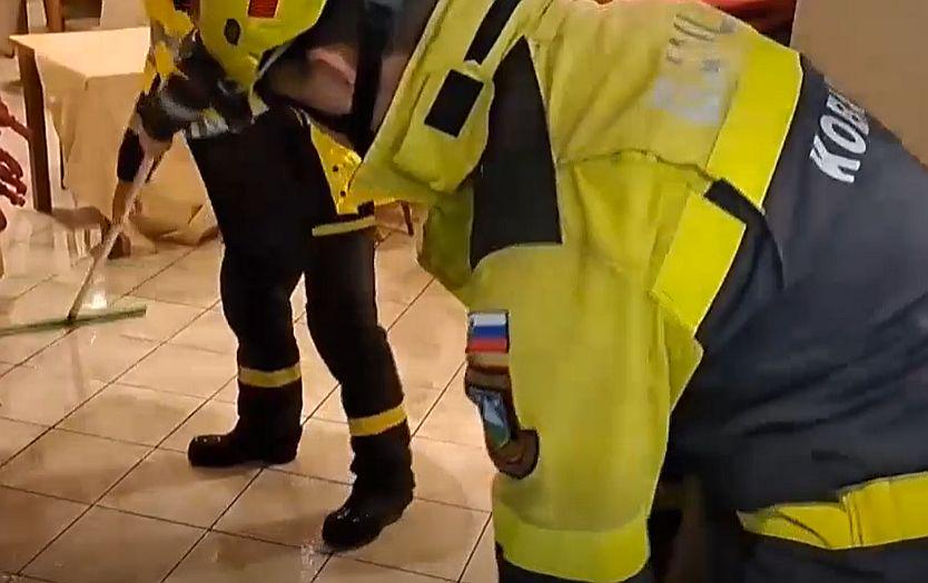 Gasilci čistijo poplavljeno hišo. Foto: TV Slovenija, zajem zaslona