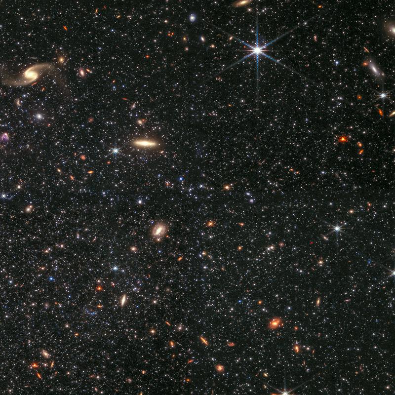 Webb ima dovolj visoko ločljivost, da lahko razloči posamezne zvezde tudi v drugih galaksiji, denimo v pritlikavi galaksiji Wolf–Lundmark–Melotte (WLM). Iz ozadja svetijo še številne druge galaksije (meglenice, osvetja), vidne so kot večje lise. Foto: NASA, ESA, CSA, IPAC, Kristen McQuinn (RU) /Zolt G. Levay (STScI)