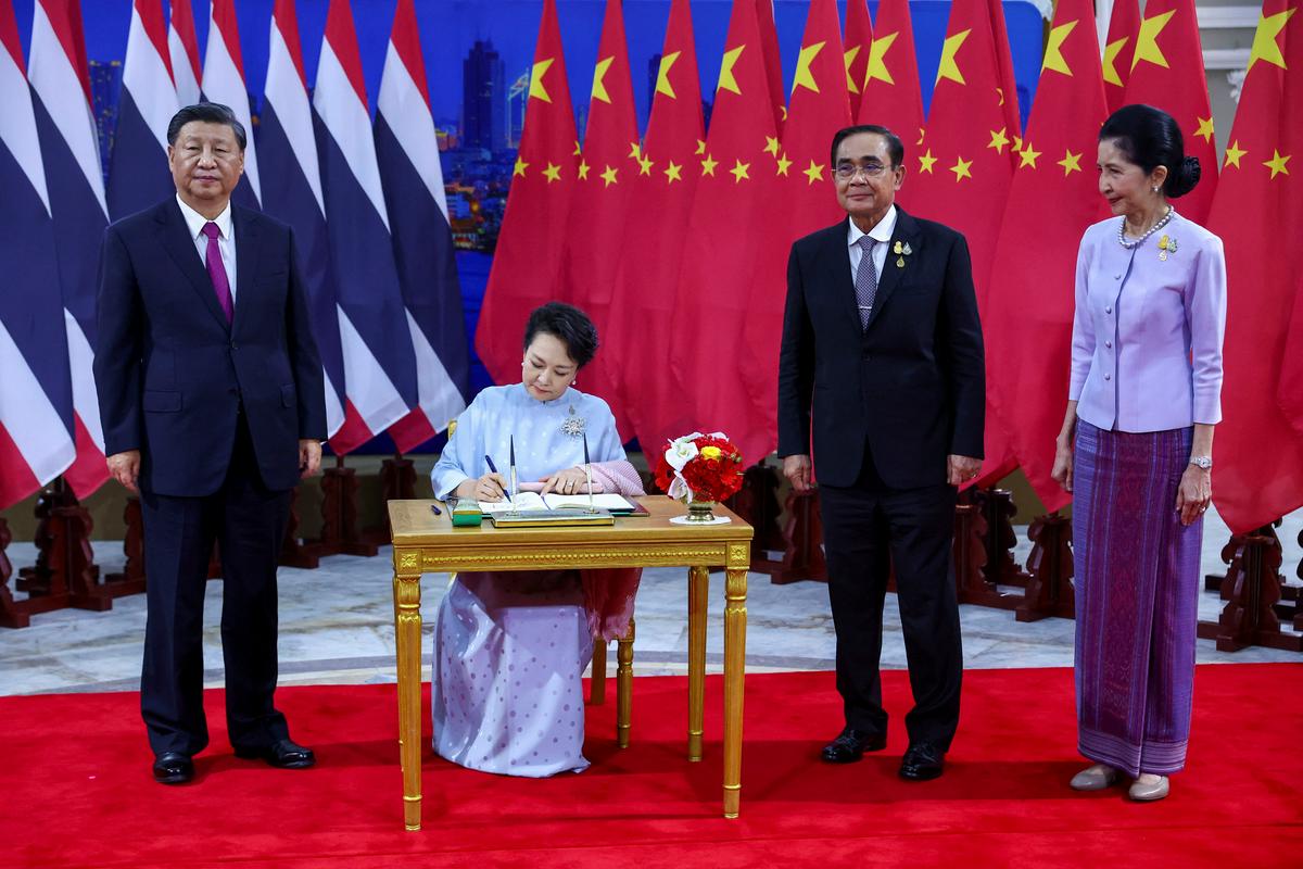 Soproga Ši Džinpinga (levo), Peng Lijuan, se vpisuje v knjigo gostov. Ob njima tajski premier Čan Oča in soproga Naraporn Čan Oča. Foto: Reuters