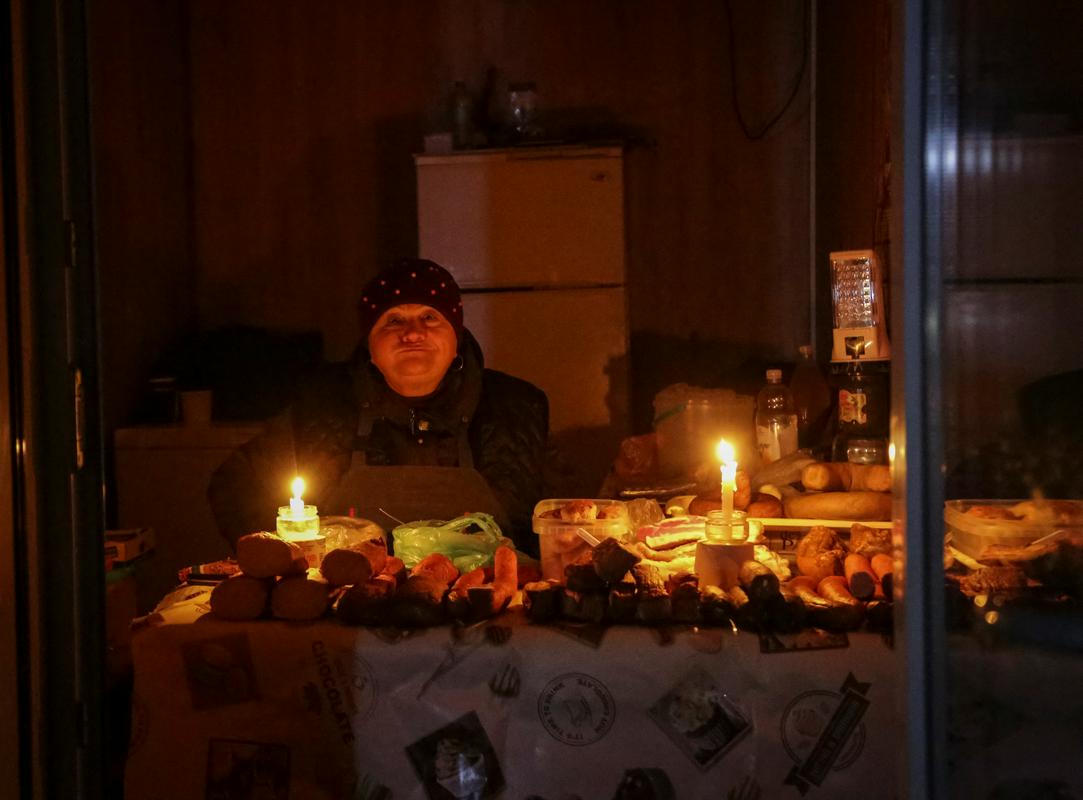 Ulična prodajalka v Odesi ob svečah čaka na morebitne kupce. Foto: Reuters