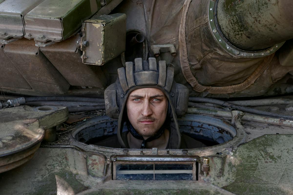 Ukrajinski vojak gleda iz tanka med boji v pokrajini Doneck na jugu Ukrajine. Fotografija je bila posneta 11. junija lani. Foto: Reuters