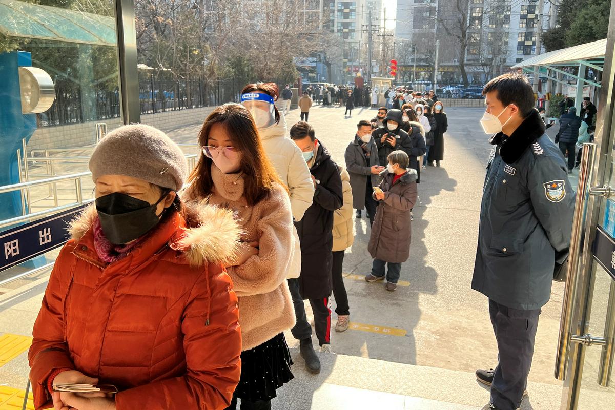 Ljudje v Pekingu v dolgih vrstah čakajo pred vladnim uradom za vstop in izstop, ki izdaja potne liste ter dovoljenja za potovanja v Hongkong, Macau in Tajvan. Foto: Reuters