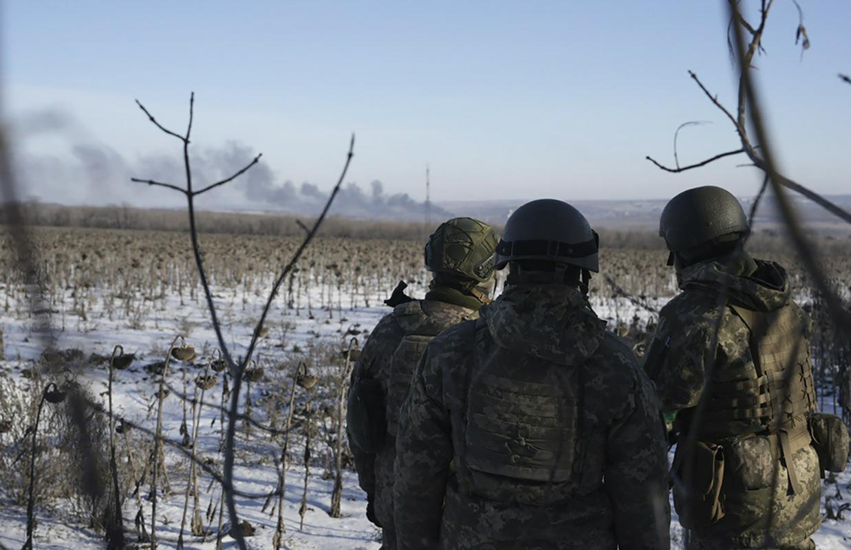 Ukrajinski vojaki opazujejo dim nad Soledarjem. Foto: AP