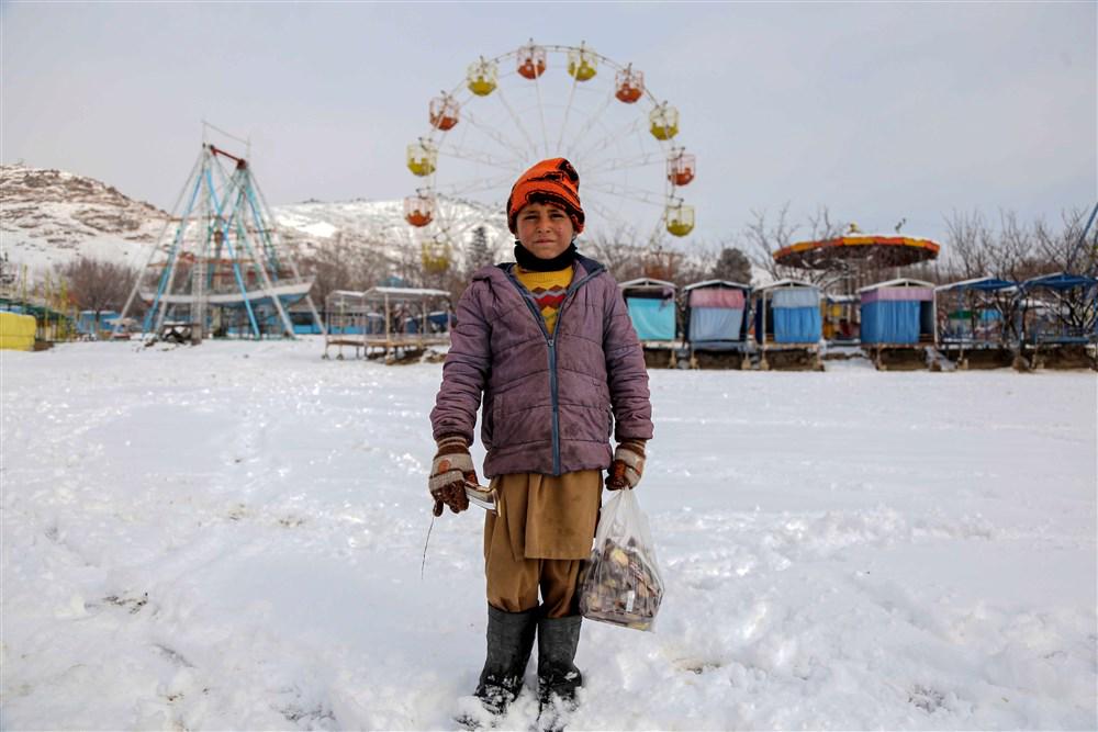 Deček v s snegom prekritem zabaviščnem parku v Kabulu. Foto: EPA