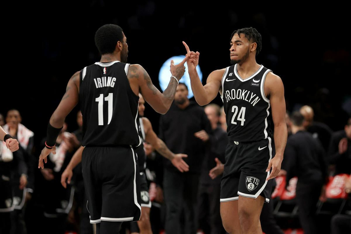 Kyrie Irving in Cam Thomas se veselita zmage Netsov, ki so odigrali že deseto zaporedno tekmo brez glavnega zvezdnika Kevina Duranta. Foto: Reuters