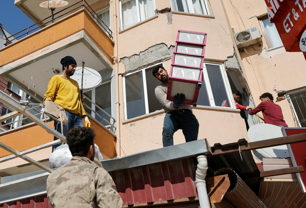 Prebivalci Antakye iz poškodovanih stanovanj nosijo svoje stvari. Foto: Reuters