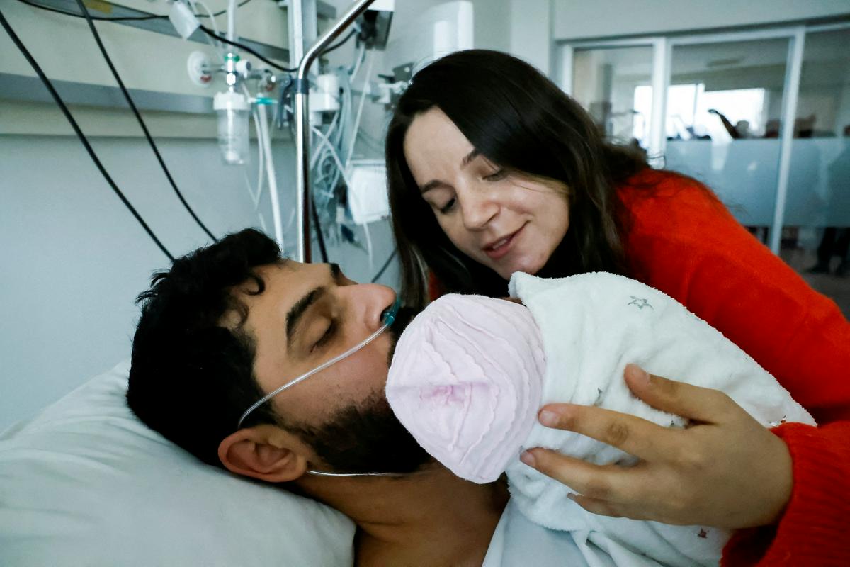 Mustafa Avci, ki so ga rešili po več kot 260 urah, je v bolnišnici v Mersinu prvič po potresu srečal ženo Bilge in hčer Almile. Foto: Reuters