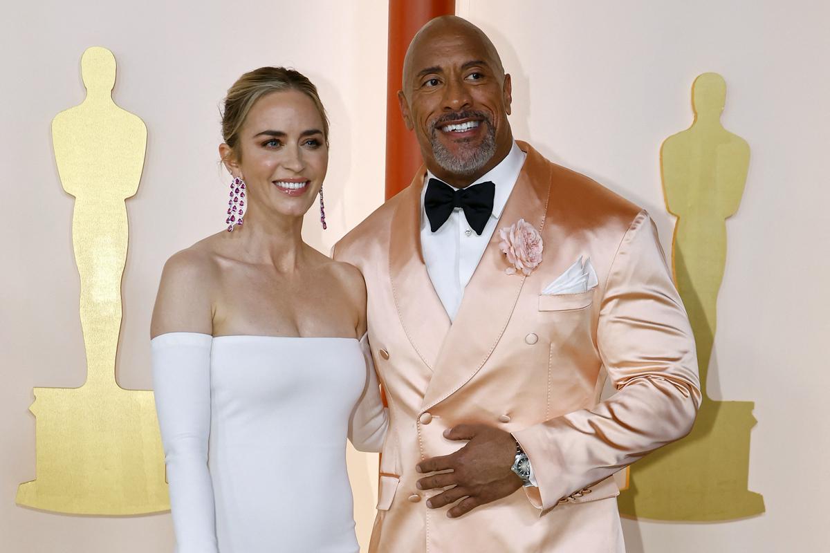 Emily Blunt and Dwayne Johnson - the first in a simple dress with straight lines, the second in a soft pink jacket.  Photo: Reuters