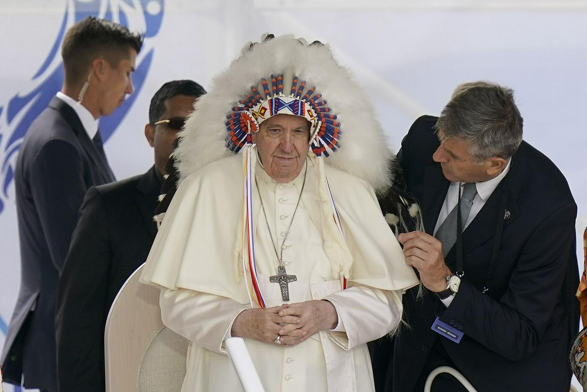 Papež Frančišek z naglavnim okrasjem, ki mu ga je ob lanskem obisku podarila delegacija staroselskega ljudstva Maskwaci iz Kanade. Foto: AP