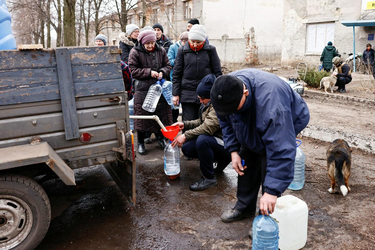 Prebivalci ukrajinskega kraja Časiv Jar blizu frontne črte v Bahmutu se po ruskem napadu na kritično infrastrukturo zanašajo na dostavo pitne vode. Foto: Reuters