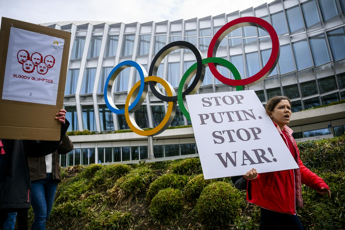 Protestniki so pred sedežem Mednarodnega olimpijskega komiteja v Ženevi zahtevali prepoved sodelovanja ruskih športnikov na olimpijskih igrah. Foto: EPA