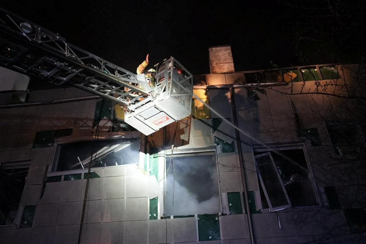 Ukrajinski reševalci v Kijevu pri stavbi, ki so jo zadeli deli letalnika. Foto: Reuters